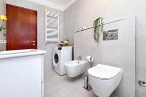 A modern bathroom with a washing machine, bidet, and toilet. - Perfect 2-bedroom apartment with AC in beautiful Rovinj (Rovinj)