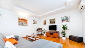 A modern living room with a sofa, coffee table, TV, and artwork on the walls. - Perfect 2-bedroom apartment with AC in beautiful Rovinj (Rovinj)