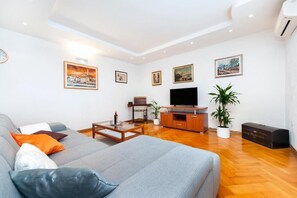 A modern living room with a sofa, coffee table, TV, and artwork on the walls. - Perfect 2-bedroom apartment with AC in beautiful Rovinj (Rovinj)