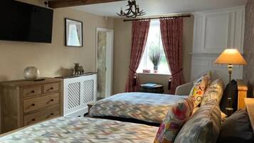A bedroom with a bed, bedside table, lamp, and a window with curtains.