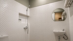 A modern bathroom with a shower, toilet, and sink.
