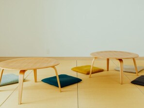 A room with two round tables and four cushions.