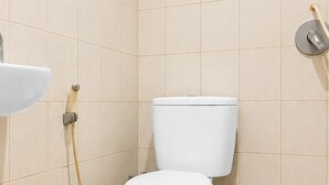 A bathroom with a toilet, a sink, and a shower. - Hotel O near RS Awal Bros Sudirman (Pekanbaru)