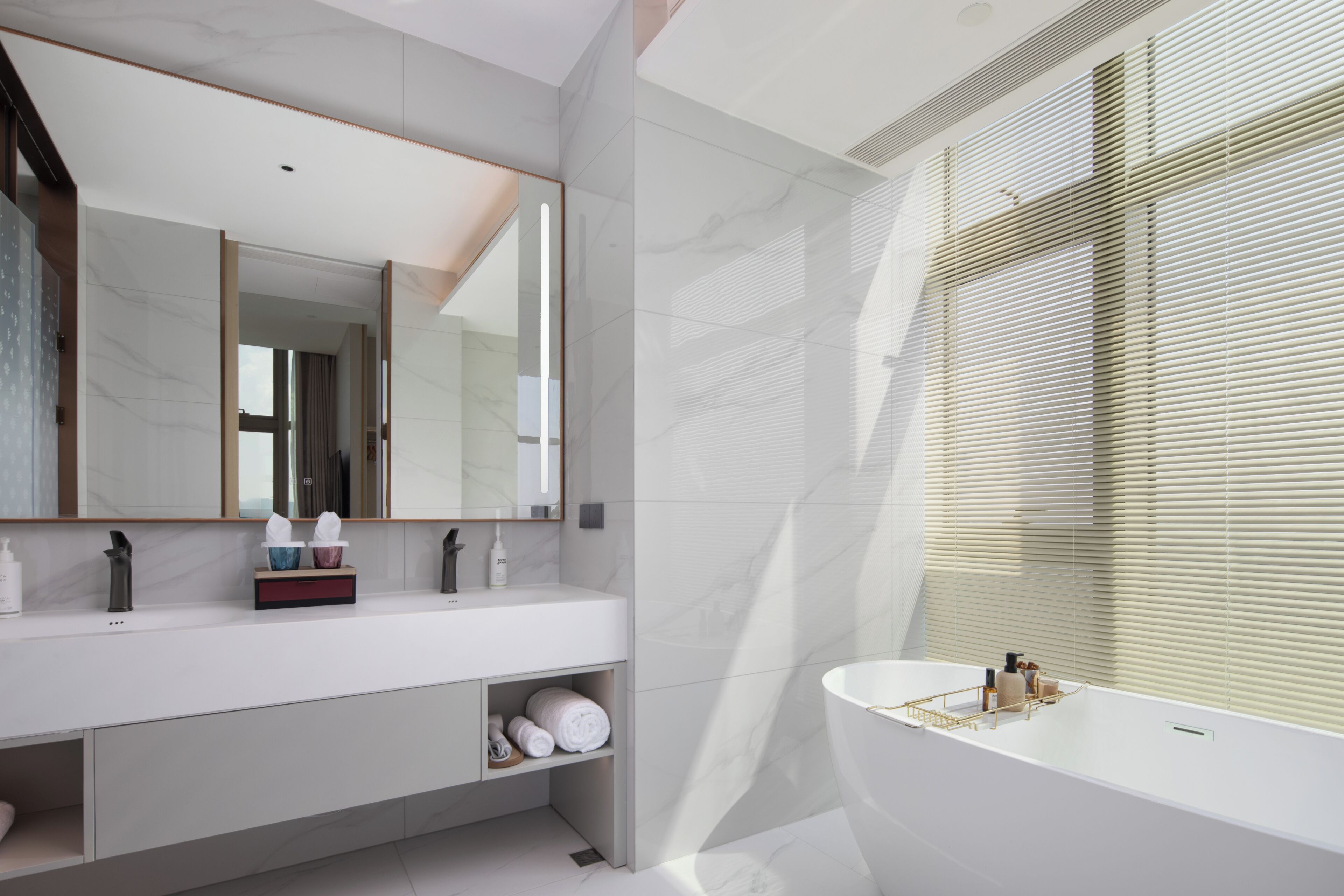 A modern bathroom with a large mirror, a white sink, and a bathtub.