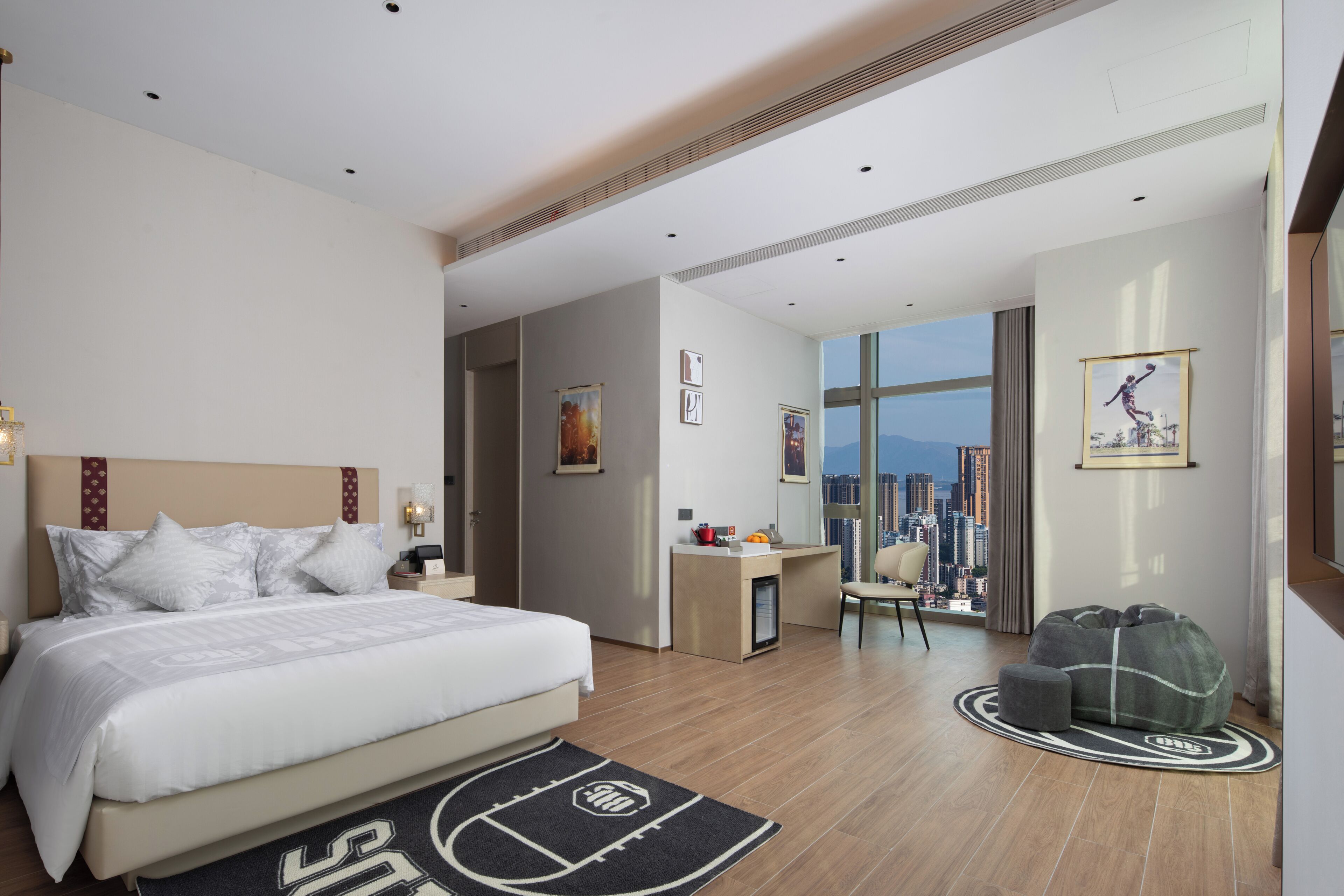 Una habitación de hotel con cama, escritorio, silla, sofá y vistas a la ciudad.
