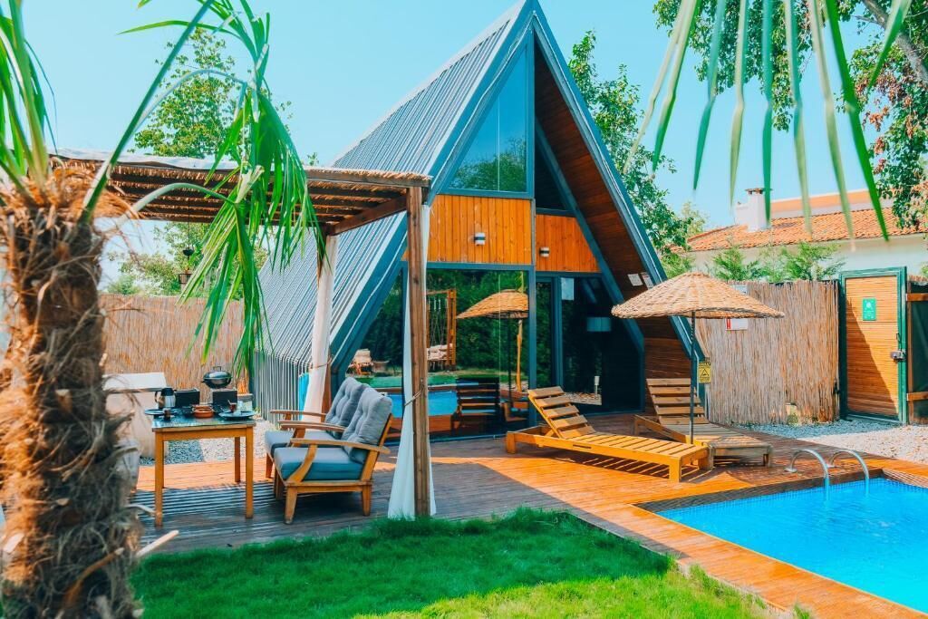 Une villa moderne dotée d’une piscine, d’une terrasse en bois et d’un espace salon extérieur.