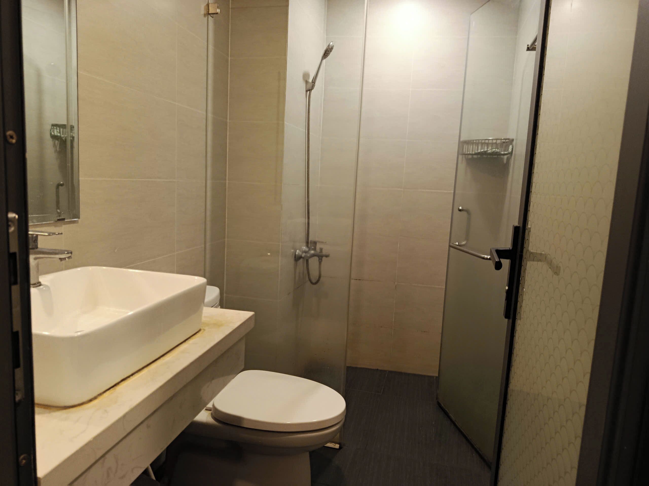 A small bathroom with a toilet, a sink, and a shower.
