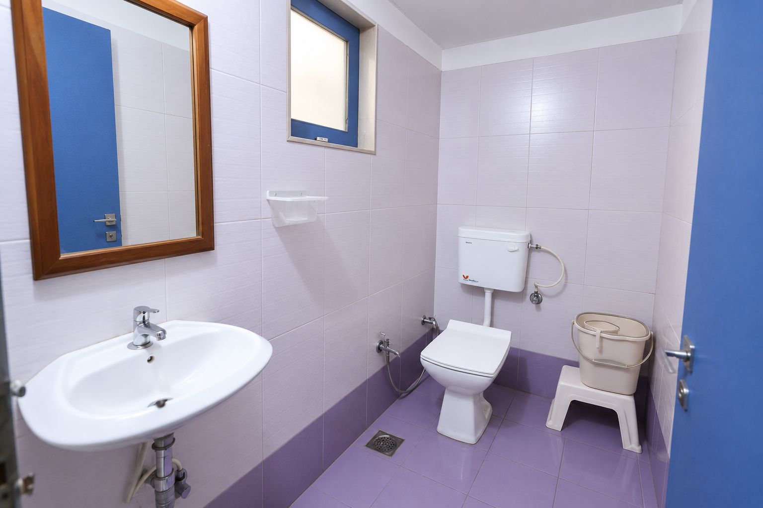 A bathroom with a white sink, a toilet, and a bidet.