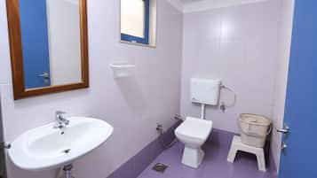 A bathroom with a white sink, a toilet, and a bidet.