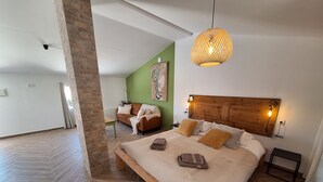 A spacious bedroom with a large bed, a wooden headboard, and a hanging light fixture. - Private studio Guesthouse Casa Dani Portugal 3 persons nearby Tomar (Santarém)