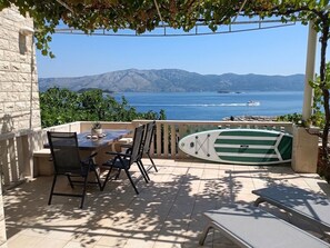 A patio with a table and chairs, a pool, and a view of the sea and mountains. - Apartment Duka "for 6" - 100m sandy beach + panoramic sea view + AirCon. & WiFi. (Lumbarda)