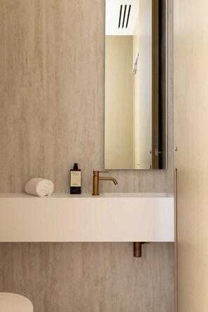 A bathroom with a white vanity, a gold faucet, and a bottle of Typology soap. - Luxurious Suite A/C - 2P - Madeleine/saint-honore (Paris)