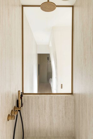 A bathroom with a large mirror, a shower head, and a towel rack. - Luxurious Suite A/C - 2P - Madeleine/saint-honore (Paris)