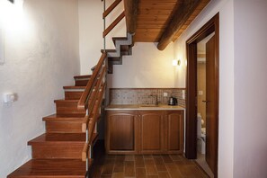 A wooden staircase leading to a kitchen with a tiled backsplash and a sink. - Casa Dell' Aristea, a Private Venetian Manor (Rethymno)