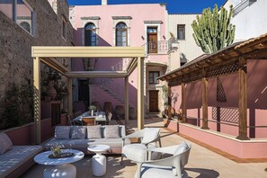An outdoor seating area with a table and chairs, a sofa, and a pergola structure. - Casa Dell' Aristea, a Private Venetian Manor (Rethymno)