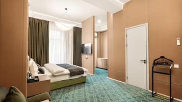 Een hotelkamer met een bed, televisie, kledingkast en een badkamer.