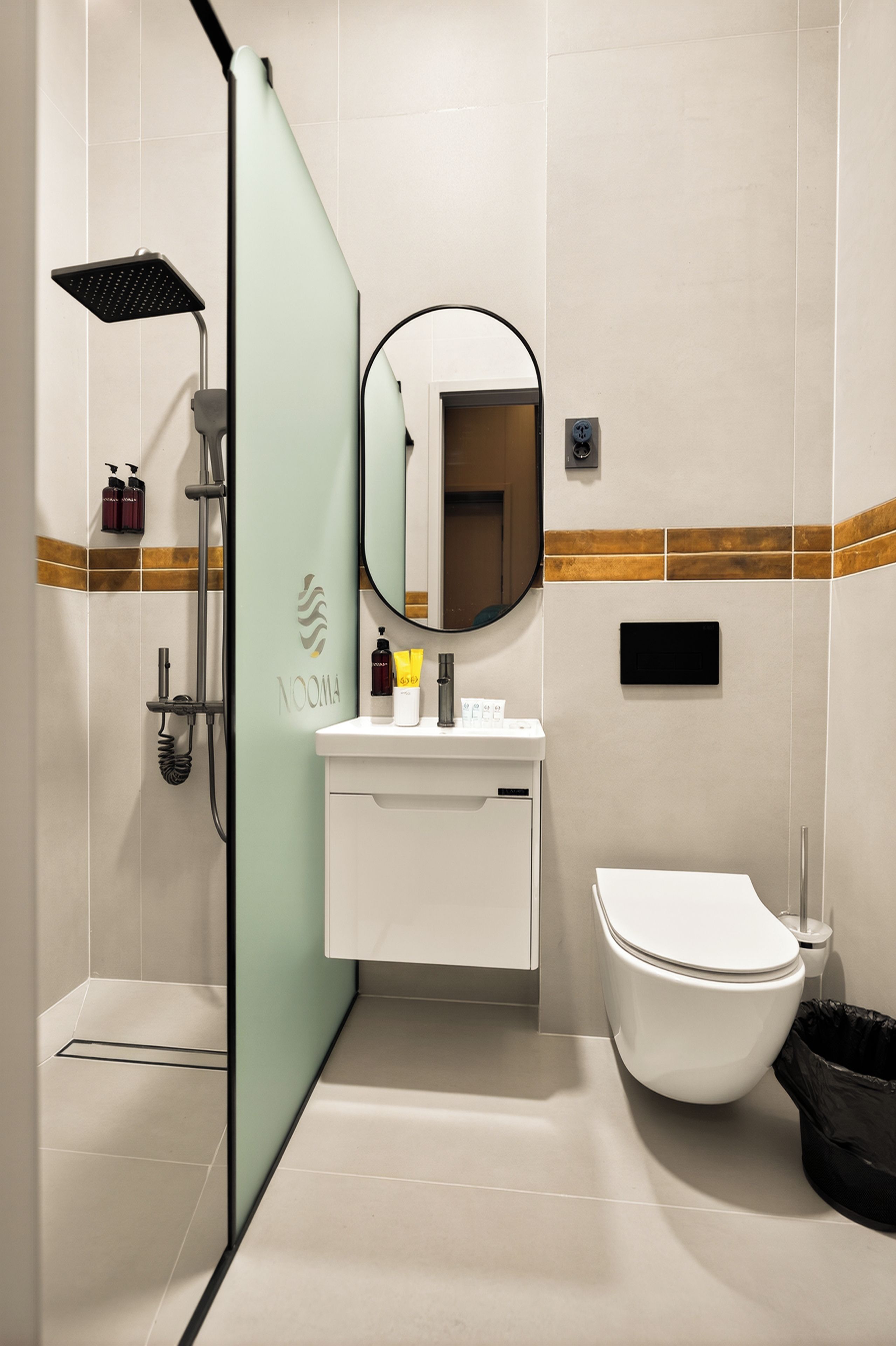 Une salle de bain moderne équipée d’une douche, de toilettes, d’un lavabo et d’un miroir.