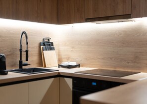 A modern kitchen with a built-in dishwasher, a sink, and a faucet. - LIV - Chic 2BR Signature Flat | Near Metro (Athens)