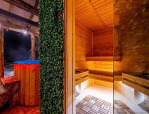 A sauna with wooden walls and benches, a blue hot tub, and a green wall. - Stylish Highlander Holiday Home, Sauna, Jacuzzi (Poronin)