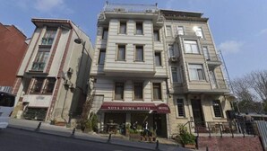 A multi-story hotel with a classic facade, a visible entrance, and a sign indicating it is the Nova Roma Hotel. - New Room Hotel (İstanbul)