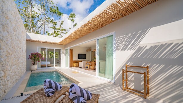 A poolside area with lounge chairs, a wooden frame, and a glass door leading to an indoor space. - Rocha Villa Uluwatu (Uluwatu)