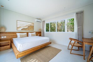 A bedroom with a large bed, a desk, and a window with curtains. - Rocha Villa Uluwatu (Uluwatu)