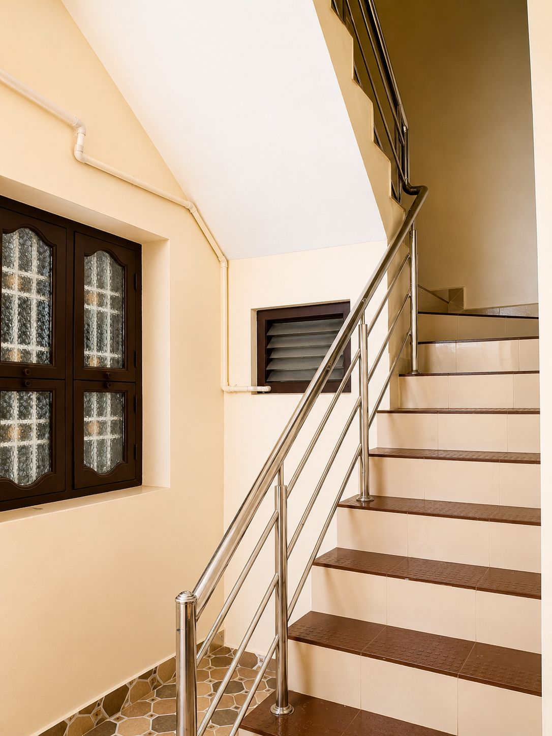 A staircase with metal railings and a tiled floor.