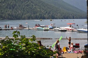 A lakeside scene with boats docked at a pier, surrounded by dense forest. - Cinnamon Bear Cabin - Tranquil 2 bedroom cabin in welcoming Lake Cushman Area (Hoodsport)