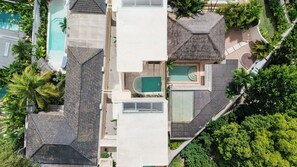 A residential property with a swimming pool, a covered patio, and lush greenery. - Kamala Villa by Betterplace (Pecatu)