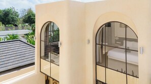 A room with a bed, a window, and a view of the outdoors. - Kamala Villa by Betterplace (Pecatu)