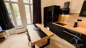 Et moderne køkken med et træbord, en sort bordplade og en indbygget ovn.