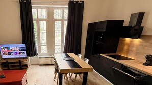 A compact living space with a kitchenette, a dining area, and a television. - Fenestre La Bourboule Park (4 people) (La Bourboule)