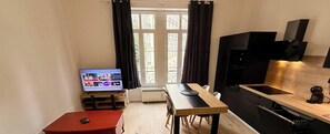 A compact living space with a kitchenette, a dining area, and a television. - Fenestre La Bourboule Park (4 people) (La Bourboule)