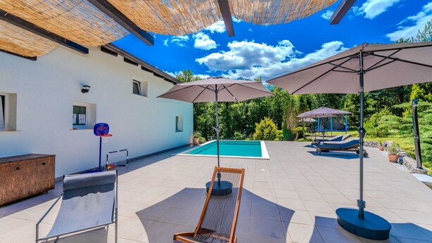 A pool area with a lounge chair, umbrella, and a basketball hoop. - Villa Sandra by Villas Guide (Veli Brgud)