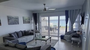 A living room with a sofa, coffee table, and a view of the outside. - Luxurious 3-bedroom Apartment With Sea Views in Ramsgate (Margate)