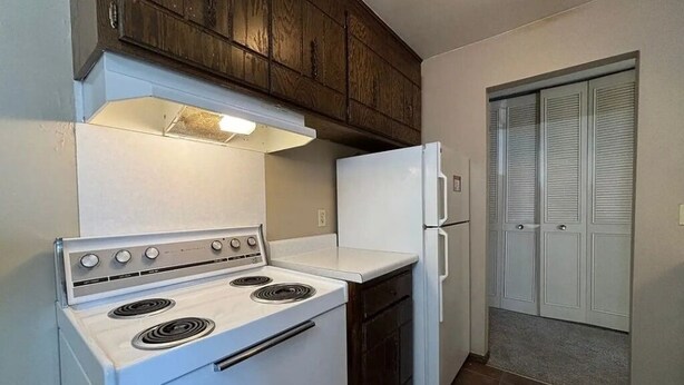A kitchen with a white stove, a white refrigerator, and wooden cabinets. - St. Paul Cozy Home Stay-Pets Ok, Pool & GYM Access - 79/Night, 1,750/Month (Saint Paul)