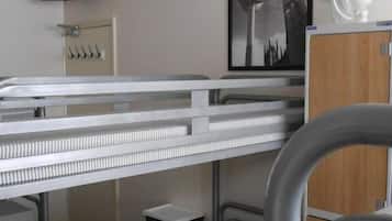 A bunk bed room with a television, a framed picture, and a fan.
