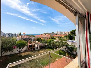Ein Balkon mit Blick auf eine Wohngegend, einschließlich Häuser und einer entfernten Küstenlinie.