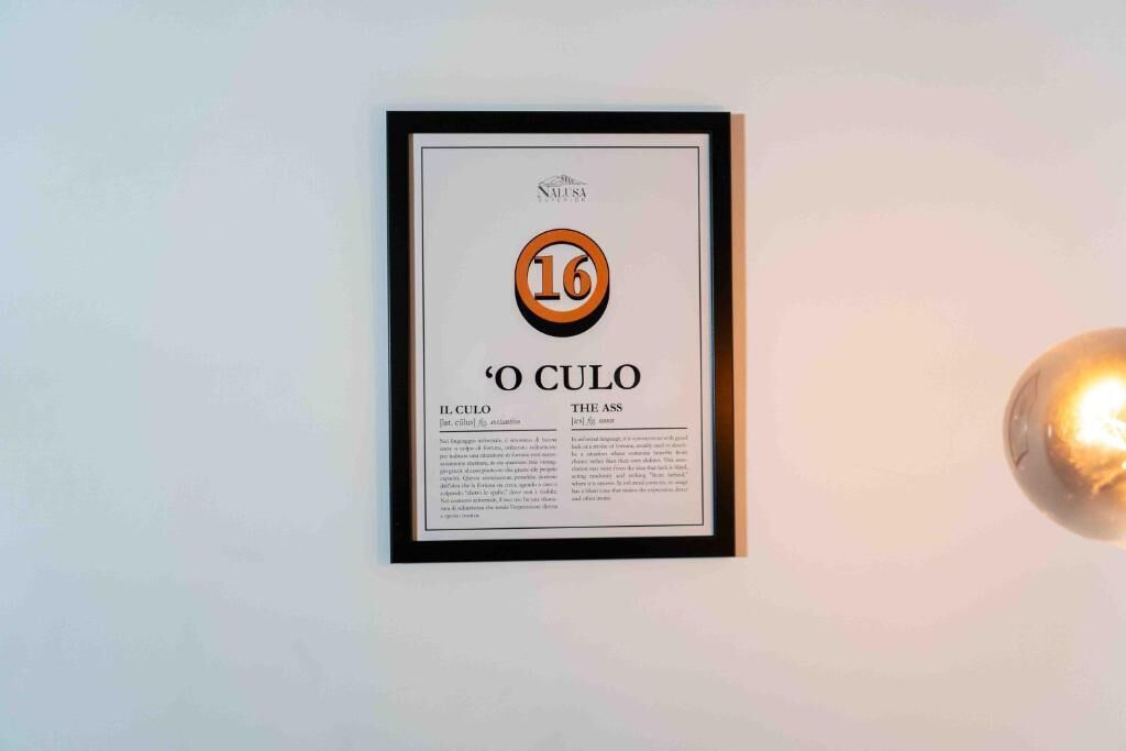 A framed certificate or award with the number 16 and the text 'O CULO' on a wall.