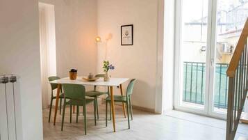 Un coin repas avec une table et des chaises, un luminaire fixé au mur et un certificat encadré accroché au mur.