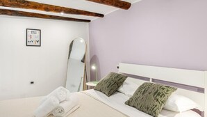 A bedroom with a bed, pillows, a mirror, and a wall-mounted picture. - NALUSA ROOMS IN CENTRO A TOLEDO (Naples)