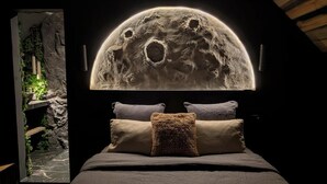 A bedroom with a bed, pillows, and a wall-mounted moon-like structure. - The Lomy Shelter. Jacuzzi with ocean view · Movie theater · Pool table (Pléneuf-Val-André)