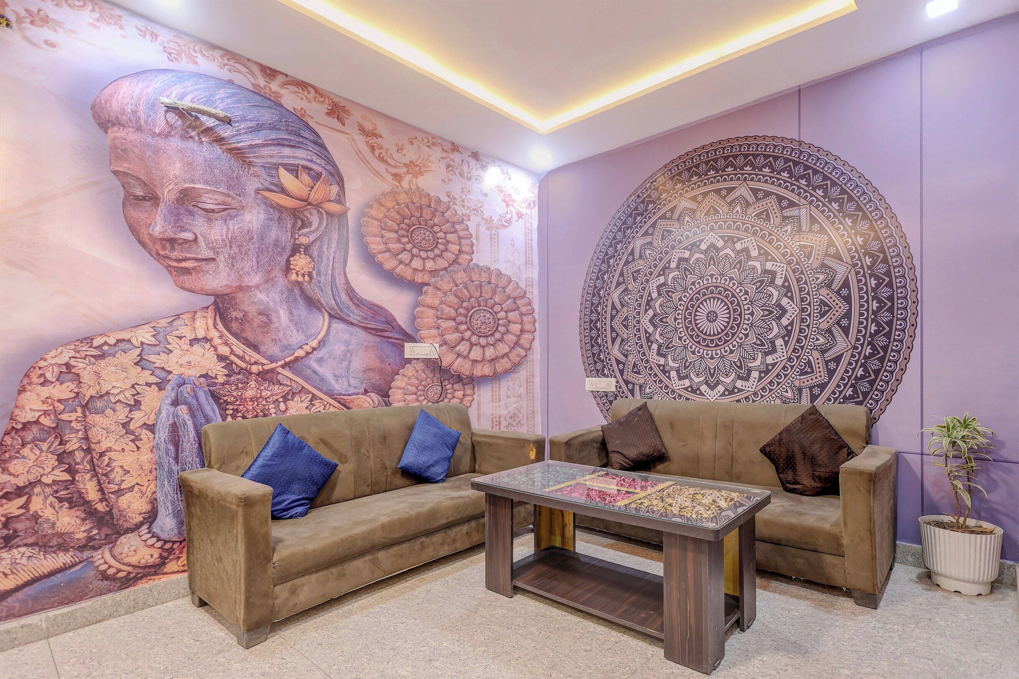 Una habitación con un conjunto de sofás, una mesa de centro y un mural decorativo grande.