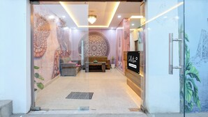 A reception area with a seating arrangement, a decorative wall, and a sign indicating the space is company-serviced. - Collection O Taj Viewpoint Agra (Agra)
