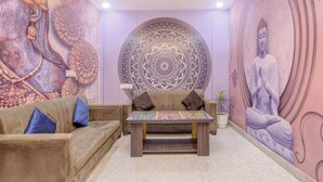 A room with a sofa, a coffee table, and a Buddha statue. - Collection O Taj Viewpoint Agra (Agra)