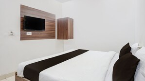 A hotel room with a bed, a flat-screen TV mounted on a wooden panel, and a wardrobe. - Collection O Taj Viewpoint Agra (Agra)