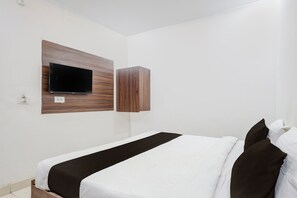 A hotel room with a bed, a flat-screen TV mounted on a wooden panel, and a wardrobe. - Collection O Taj Viewpoint Agra (Agra)