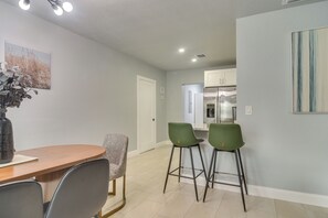 A dining area with a wooden table and chairs, a vase with flowers, and a painting on the wall. - 4 Mi to Beach! Dual-Unit Safety Harbor Retreat (Safety Harbor)