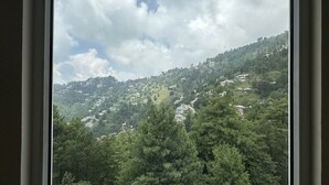 A mountainous landscape with scattered buildings, likely a rural or semi-rural area.