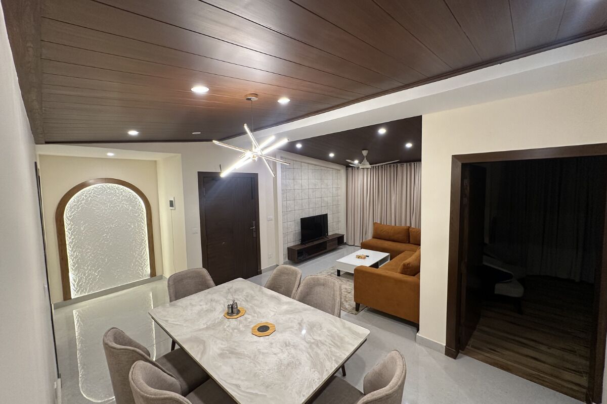 A modern living room with a dining area, a television, and a sofa.